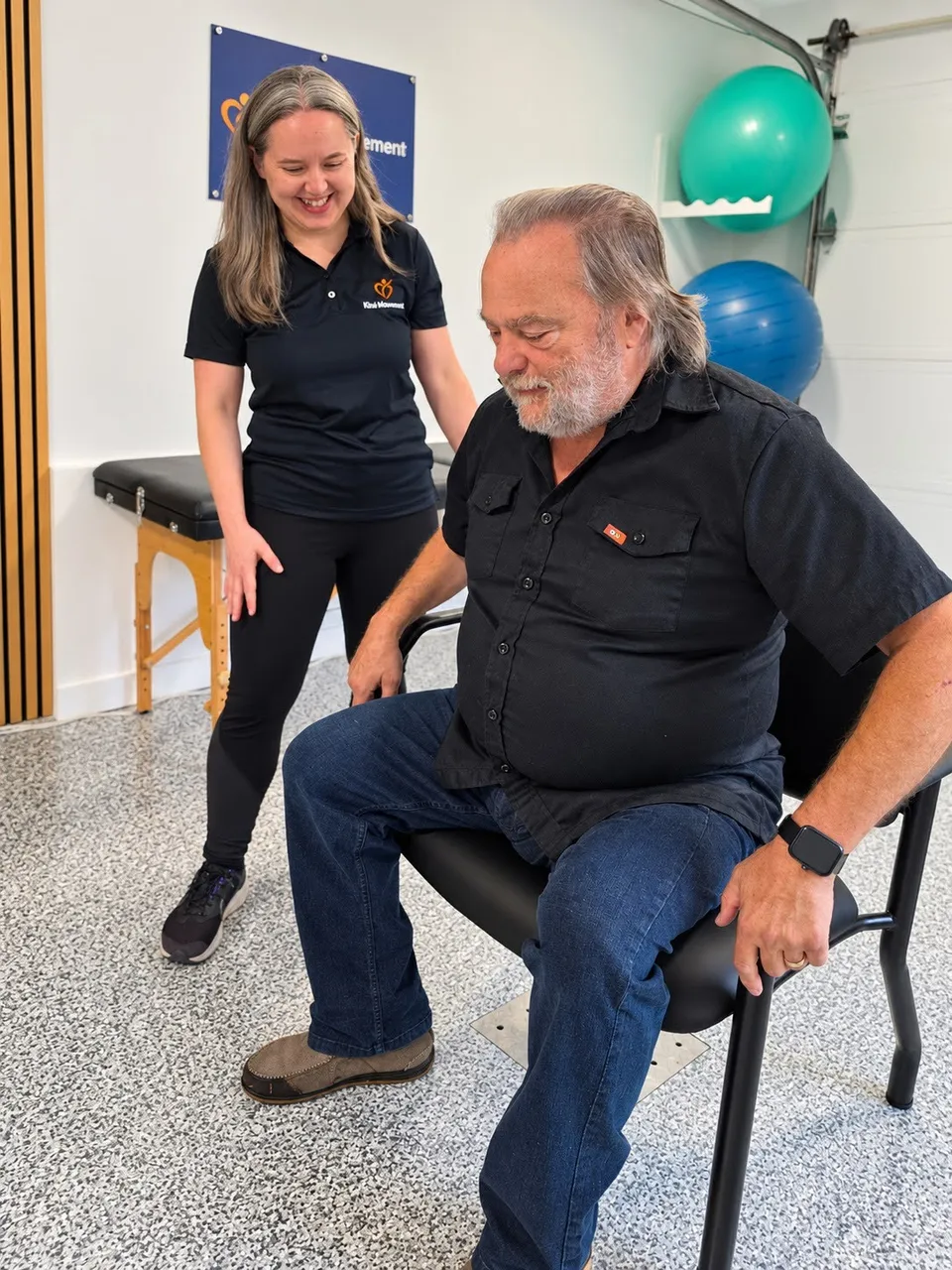 Je me tiens debout près d'un participant assis sur une chaise, dans mon espace.